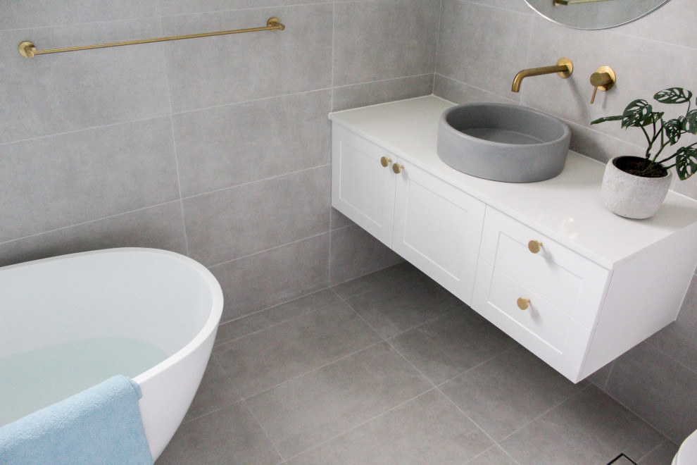 Inspiration for a large modern kids bathroom in Perth with shaker cabinets, white cabinets, a freestanding tub, a corner shower, a one-piece toilet, gray tile, porcelain tile, grey walls, porcelain floors, a vessel sink, concrete benchtops, grey floor, a hinged shower door, white benchtops, a single vanity and a floating vanity.