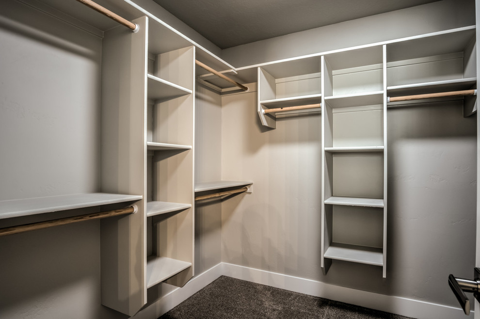 Design ideas for a mid-sized arts and crafts gender-neutral walk-in wardrobe in Boise with open cabinets, carpet and grey floor.