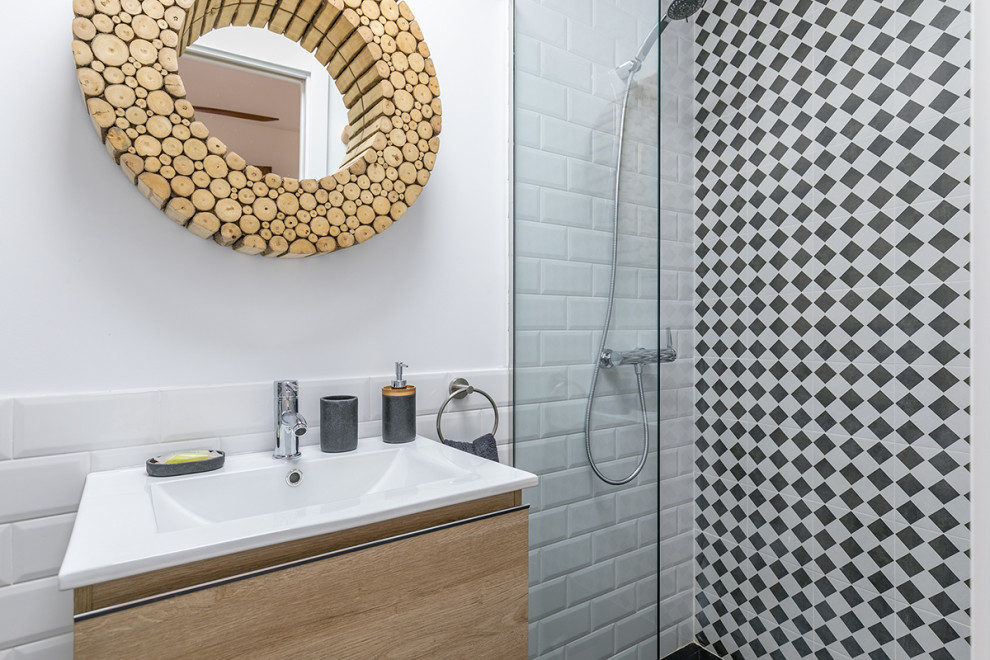 Small contemporary 3/4 bathroom in Madrid with flat-panel cabinets, white cabinets, a curbless shower, a one-piece toilet, black and white tile, ceramic tile, white walls, ceramic floors, black floor, a hinged shower door and a floating vanity.