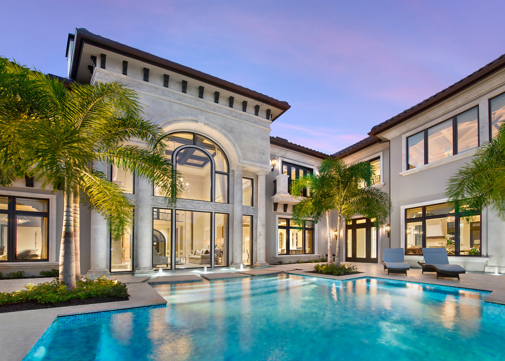 Example of a transitional two-story stucco exterior home design in Miami