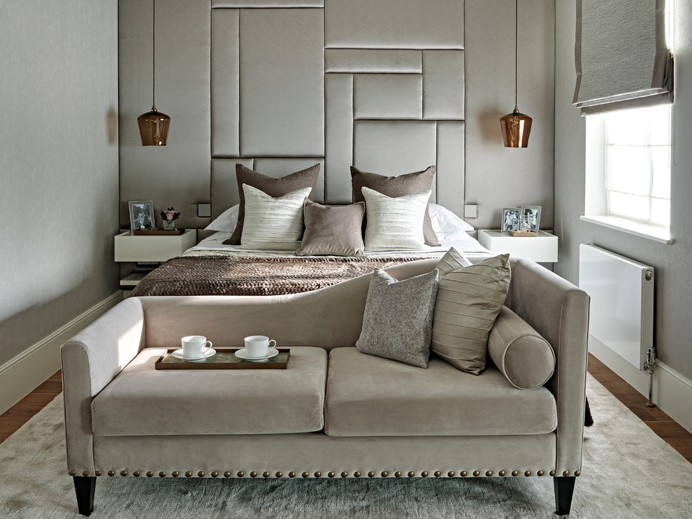 This is an example of a mid-sized transitional master bedroom in London with grey walls.