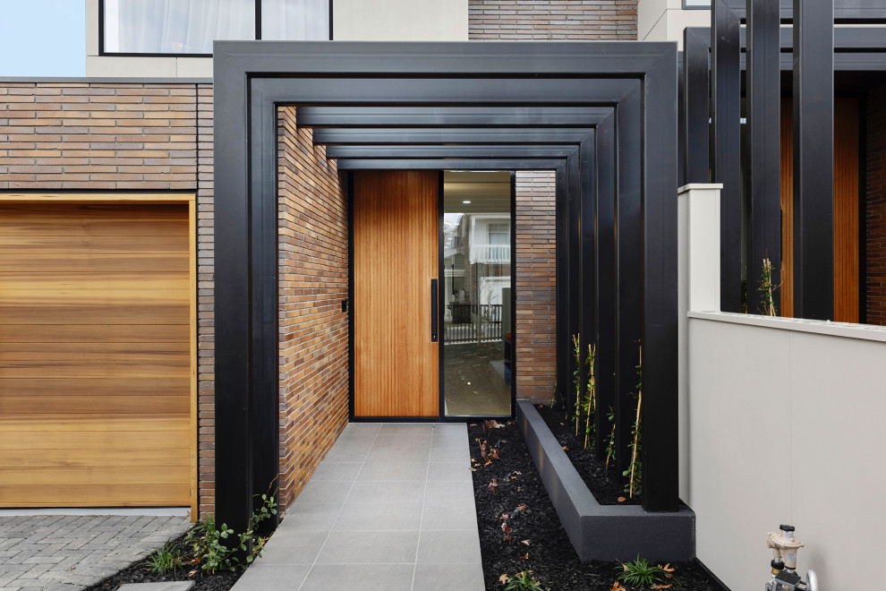 Photo of a modern brick brown townhouse exterior in Melbourne with a tile roof.