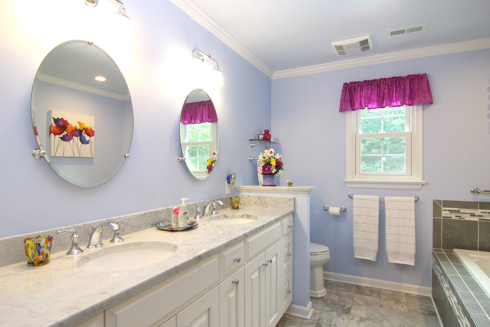 Drop-in bathtub - mid-sized transitional master gray tile and porcelain tile linoleum floor drop-in bathtub idea with an undermount sink, raised-panel cabinets, white cabinets, marble countertops, a two-piece toilet and purple walls