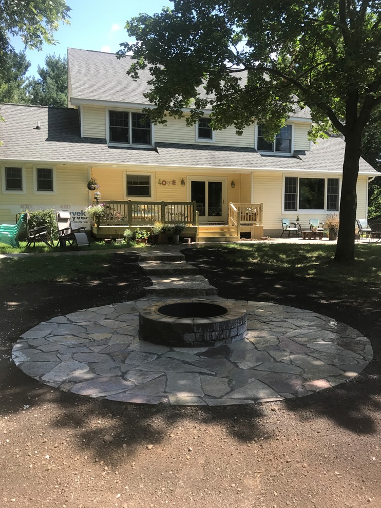 Photo of a small rustic backyard stone landscaping in Detroit with a fire pit.