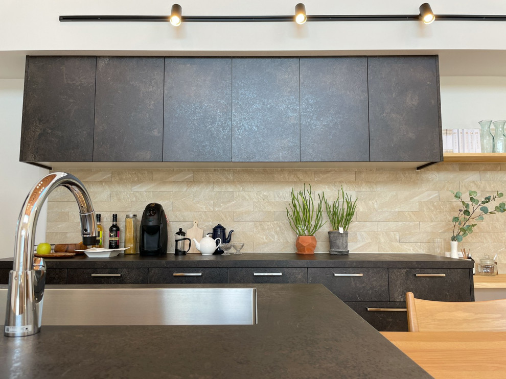 Cette photo montre une cuisine avec une crédence noire, parquet clair, plan de travail noir et un plafond en papier peint.