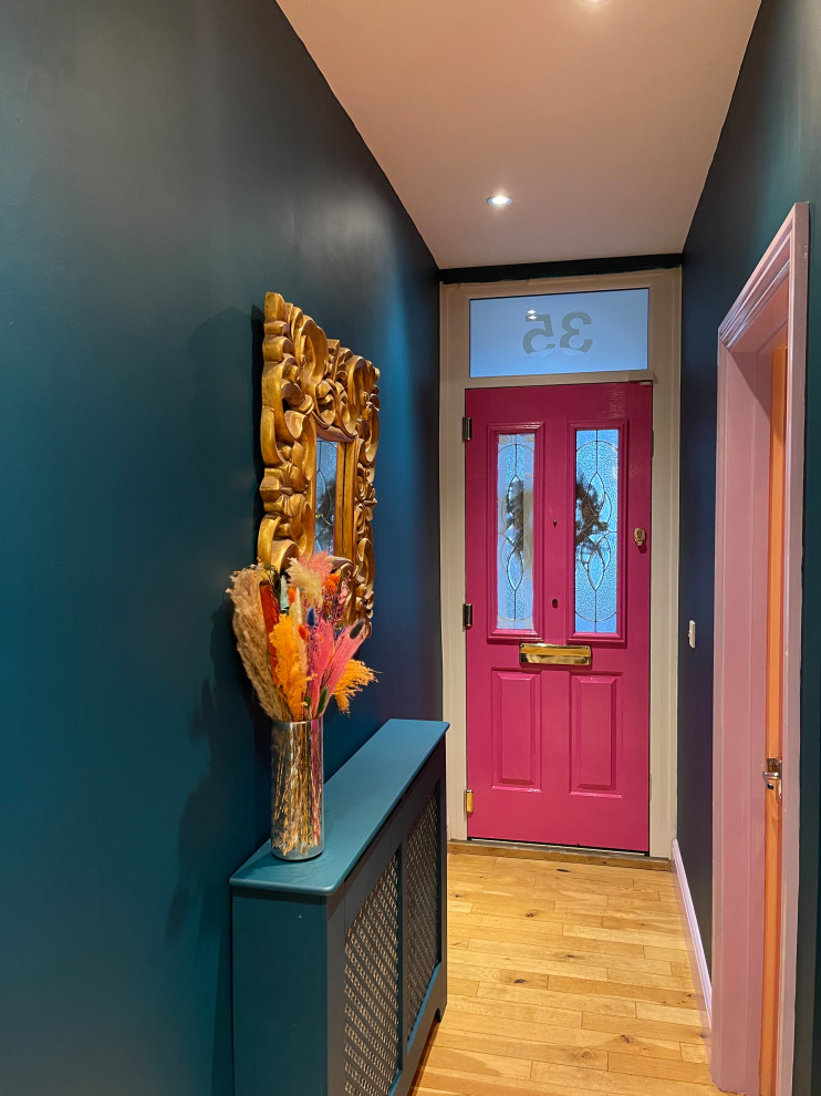 Esempio di un piccolo corridoio boho chic con pareti blu, parquet chiaro, una porta singola e pavimento beige