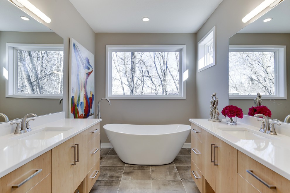 This is an example of a mid-sized modern master bathroom in Minneapolis with flat-panel cabinets, light wood cabinets, a freestanding tub, a curbless shower, a one-piece toilet, grey walls, plywood floors, an undermount sink, engineered quartz benchtops and a hinged shower door.