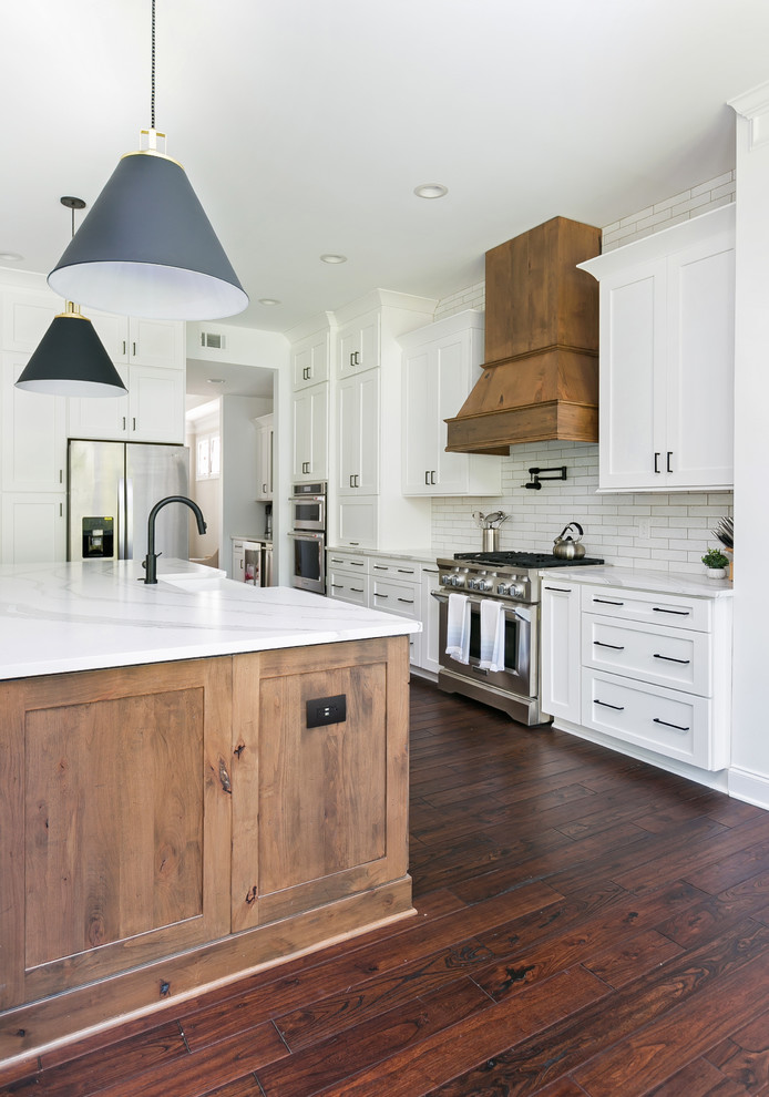 Inspiration for a huge country open concept kitchen remodel in Charleston with a farmhouse sink, shaker cabinets, white cabinets, quartz countertops, white backsplash, brick backsplash, stainless steel appliances, an island and white countertops