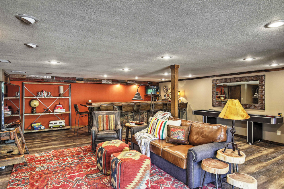 Inspiration for a mid-sized rustic walk-out vinyl floor and brown floor basement remodel with multicolored walls, a standard fireplace and a metal fireplace