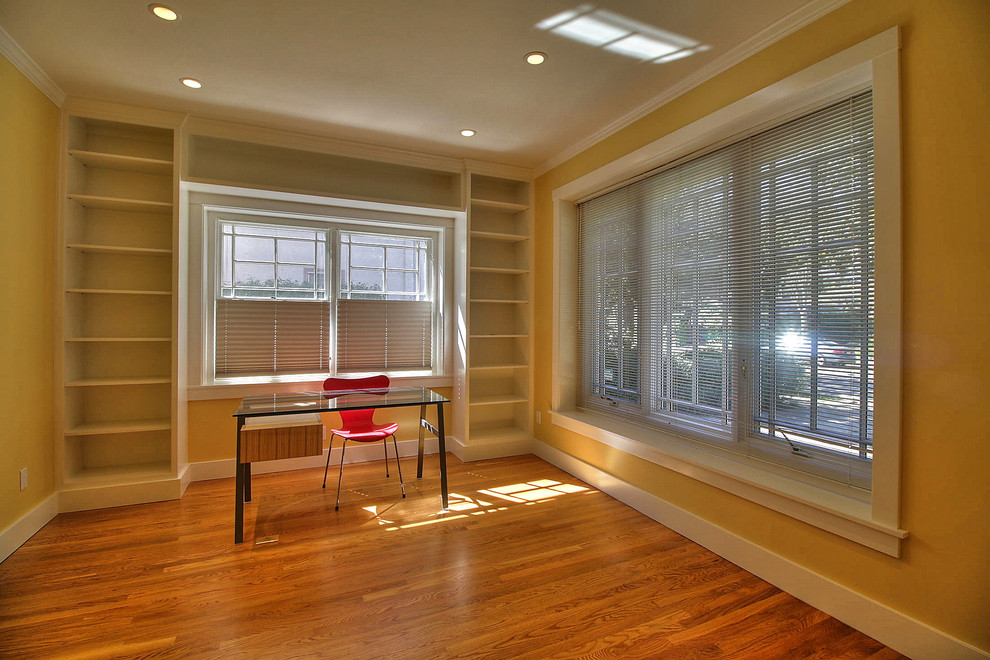 This is an example of an arts and crafts home office in San Francisco with yellow walls and medium hardwood floors.