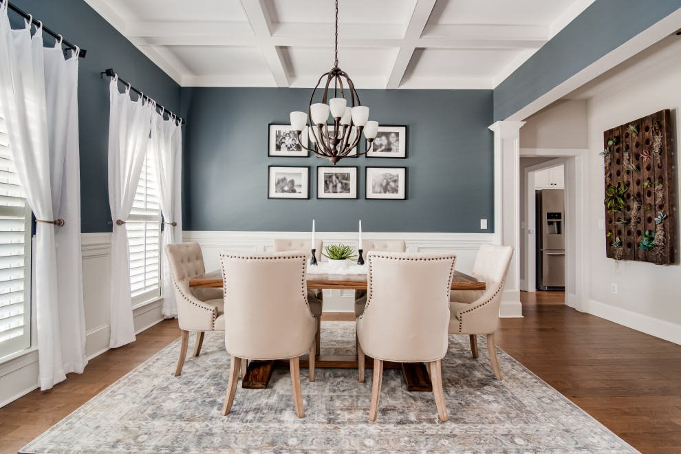 Immagine di una sala da pranzo aperta verso la cucina country di medie dimensioni con pareti blu, pavimento in legno massello medio, pavimento marrone e soffitto a cassettoni
