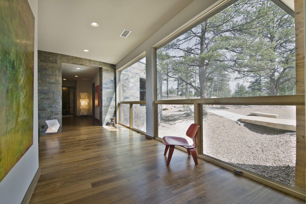 This is an example of a contemporary hallway in Denver with white walls and medium hardwood floors.