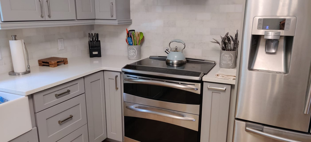 Foto på ett vintage vit kök och matrum, med skåp i shakerstil, grå skåp, bänkskiva i kvarts, vitt stänkskydd och rostfria vitvaror