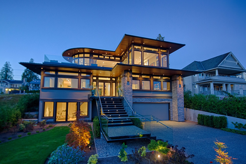 Mid-sized contemporary three-storey grey house exterior in Vancouver with mixed siding and a flat roof.