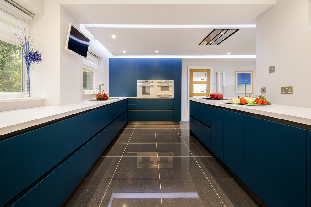 Contemporary kitchen in Devon with a drop-in sink, flat-panel cabinets, blue cabinets, white appliances and with island.