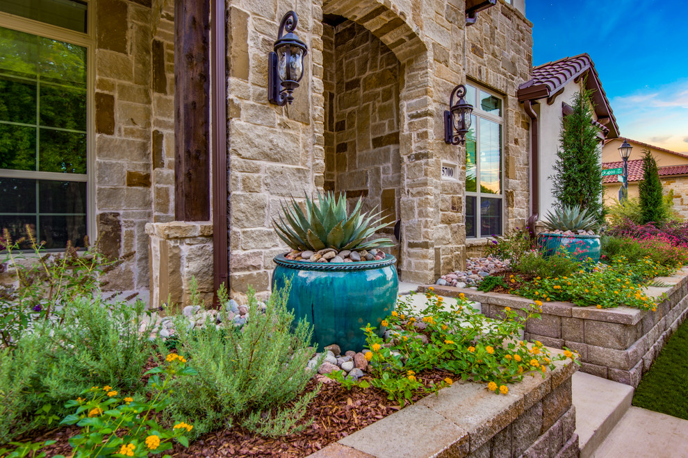 Inspiration for a mid-sized mediterranean front yard full sun garden in Dallas with a retaining wall and concrete pavers.