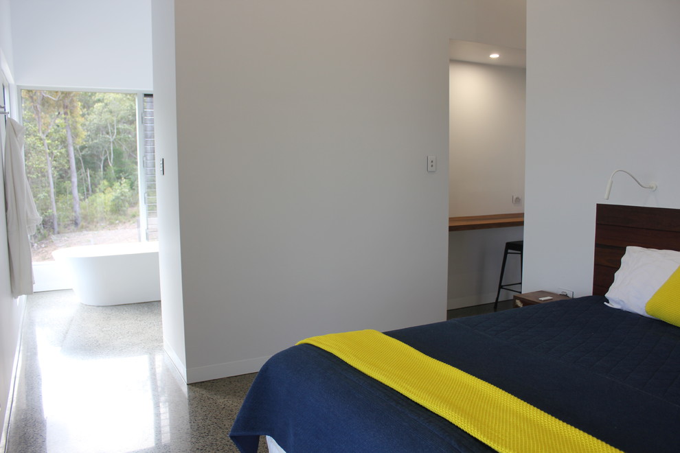 Photo of a small contemporary guest bedroom in Other with white walls, concrete floors and multi-coloured floor.