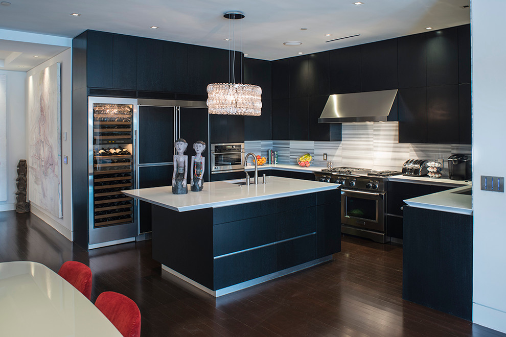 Contemporary u-shaped open plan kitchen in Boston with flat-panel cabinets, black cabinets, grey splashback and panelled appliances.
