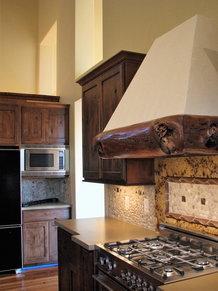 Example of a large mountain style u-shaped medium tone wood floor and brown floor open concept kitchen design in Seattle with a farmhouse sink, beaded inset cabinets, distressed cabinets, concrete countertops, beige backsplash, stone tile backsplash, stainless steel appliances and an island