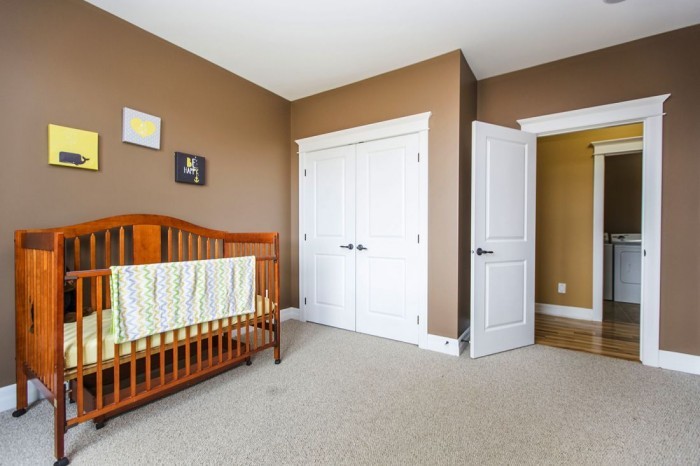 This is an example of a traditional bedroom in Ottawa with brown walls and carpet.