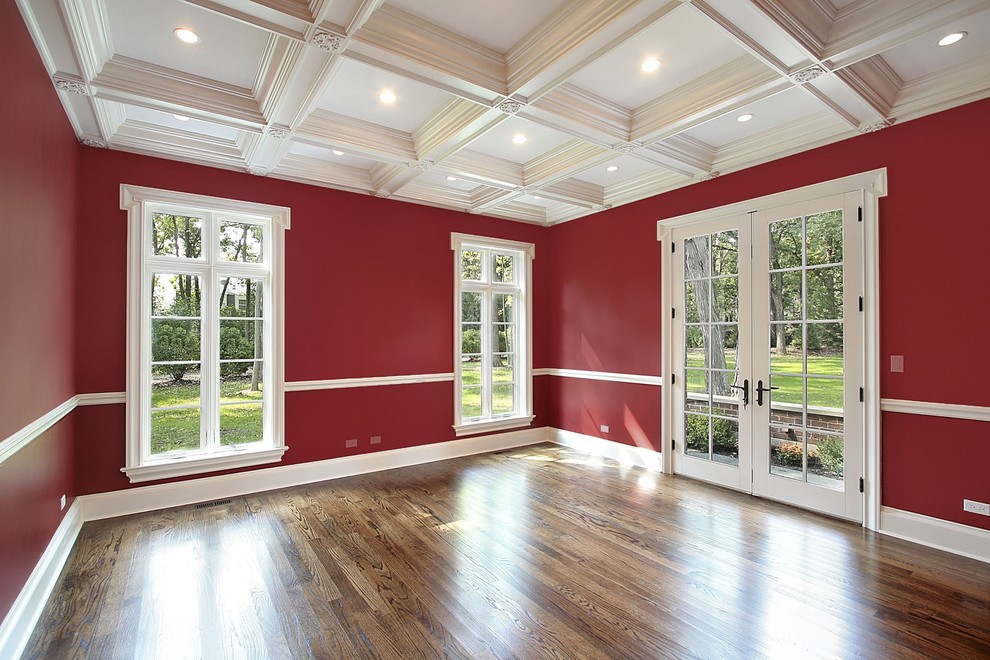 This is an example of a mid-sized traditional enclosed living room in Boston with red walls, dark hardwood floors and no fireplace.