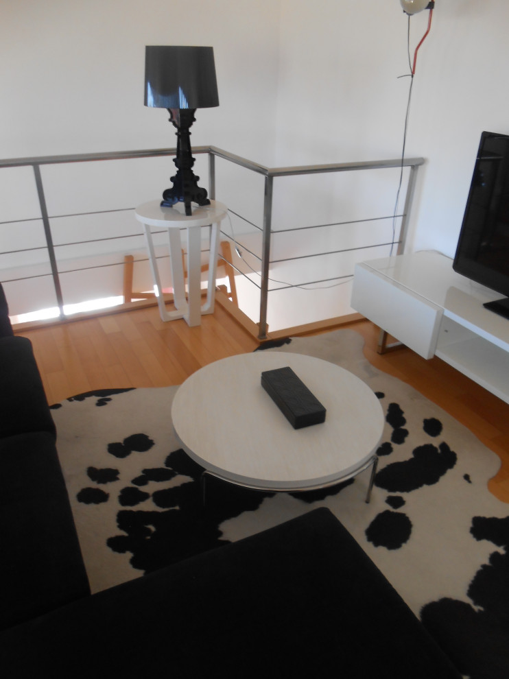 Großes, Offenes Modernes Wohnzimmer mit weißer Wandfarbe, hellem Holzboden und TV-Wand in Sonstige