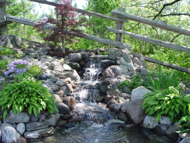 This is an example of a mid-sized asian backyard partial sun formal garden for spring in Ottawa with with pond.