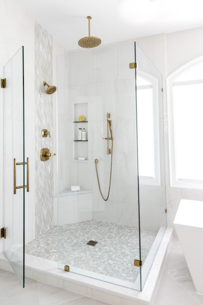 Свежая идея для дизайна: главная ванная комната среднего размера в стиле неоклассика (современная классика) с фасадами с утопленной филенкой, белыми фасадами, отдельно стоящей ванной, душем, белой плиткой, мраморной плиткой, серыми стенами, полом из керамогранита, врезной раковиной, мраморной столешницей, серым полом, душем с распашными дверями, белой столешницей, нишей, тумбой под две раковины и встроенной тумбой - отличное фото интерьера