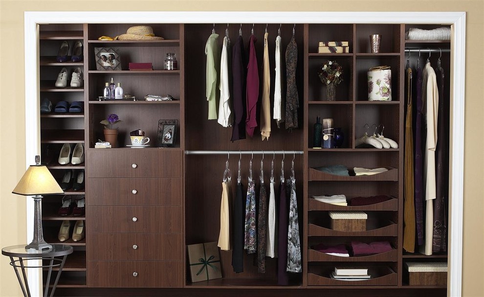 Design ideas for a small modern gender-neutral built-in wardrobe in Other with flat-panel cabinets and dark wood cabinets.