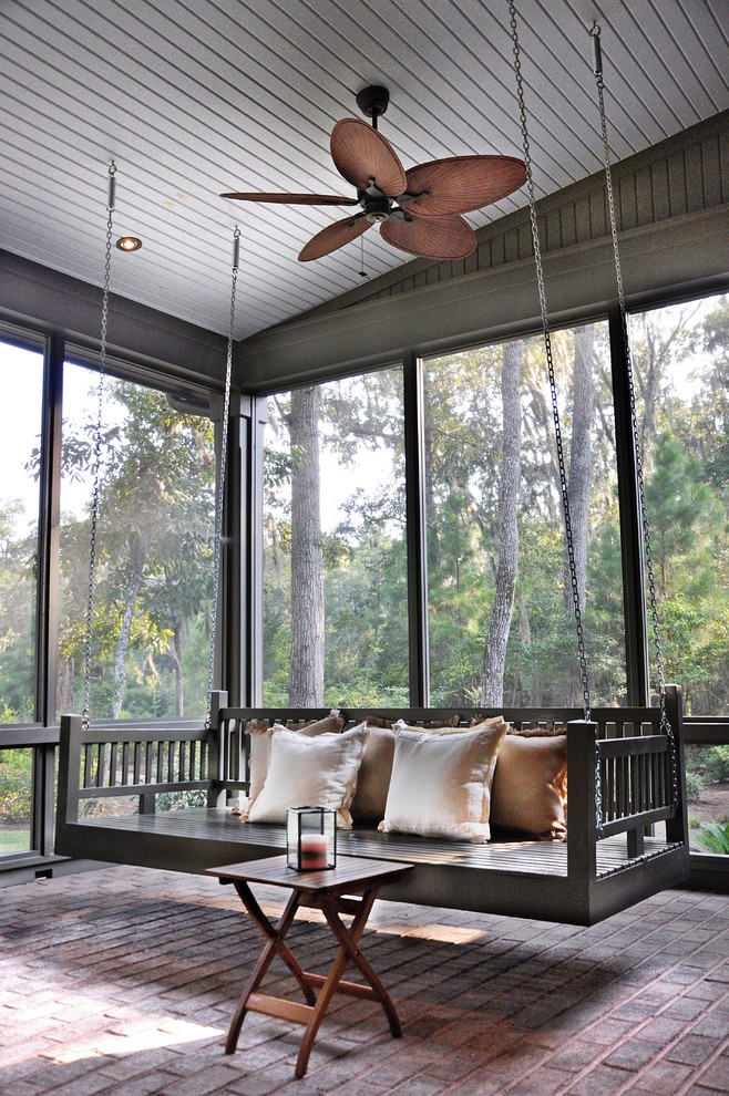 Photo of a traditional screened-in verandah in Atlanta with brick pavers and a roof extension.