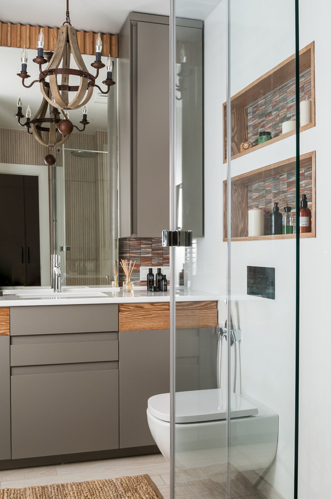 This is an example of a contemporary 3/4 bathroom in Other with flat-panel cabinets, grey cabinets, a wall-mount toilet, white walls, an undermount sink, beige floor, white benchtops and porcelain floors.