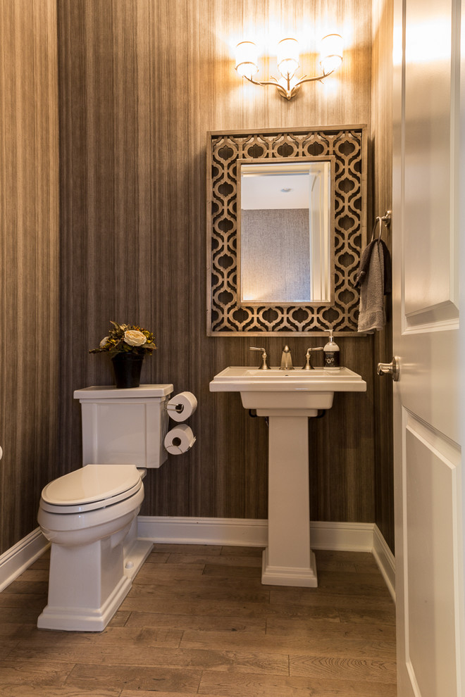 Example of a small transitional medium tone wood floor powder room design in Denver with a pedestal sink