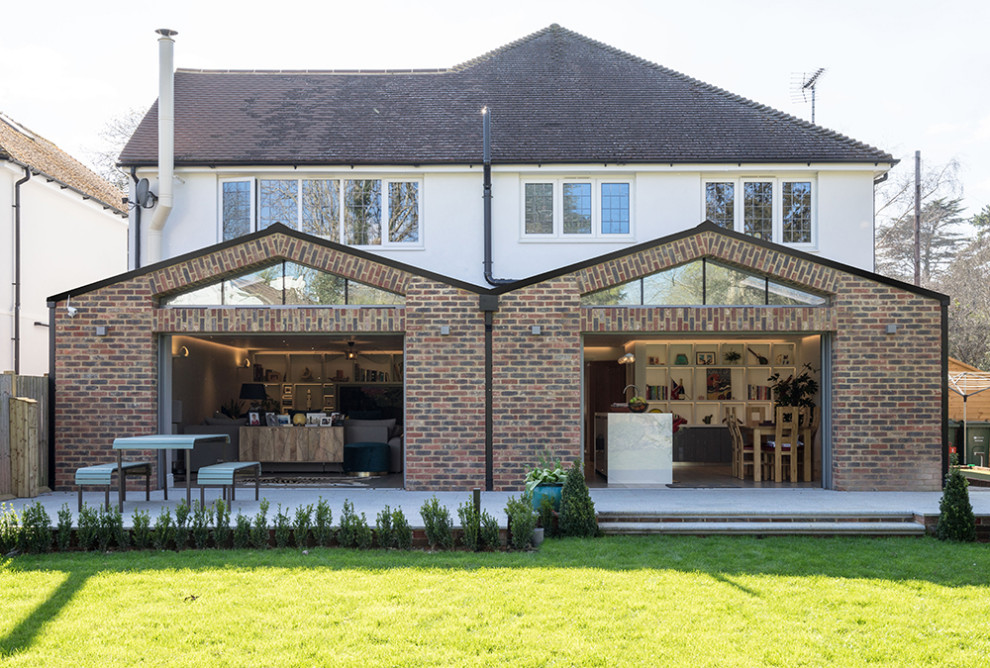 Photo of a large contemporary back patio in Surrey with natural stone paving.