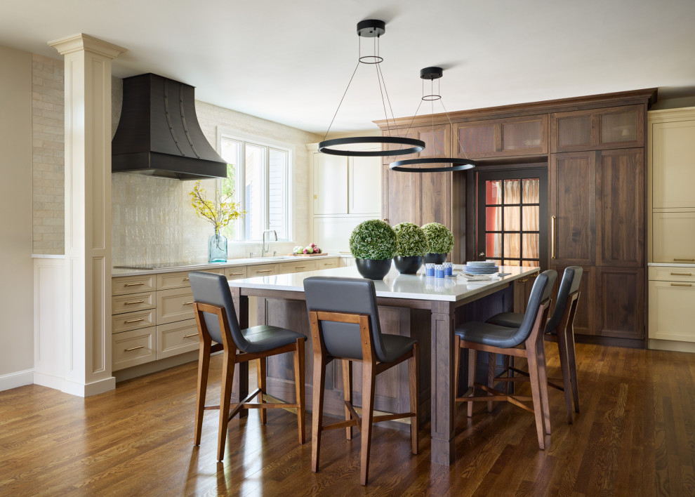 Kitchen - transitional l-shaped dark wood floor and brown floor kitchen idea in Boston with recessed-panel cabinets, beige cabinets, beige backsplash, paneled appliances, an island and white countertops