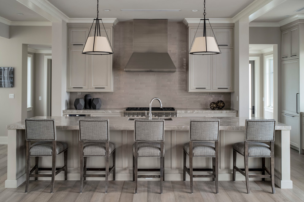 Inspiration for a mid-sized transitional galley kitchen in Miami with recessed-panel cabinets, grey cabinets, marble benchtops, grey splashback, subway tile splashback, stainless steel appliances, with island, grey floor, an undermount sink and medium hardwood floors.