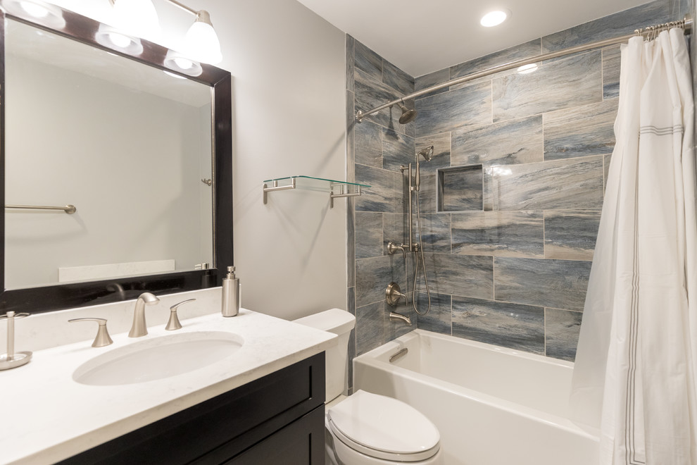 Design ideas for a mid-sized transitional master bathroom in DC Metro with shaker cabinets, dark wood cabinets, an alcove tub, a shower/bathtub combo, a two-piece toilet, multi-coloured tile, porcelain tile, grey walls, an undermount sink, quartzite benchtops and a shower curtain.