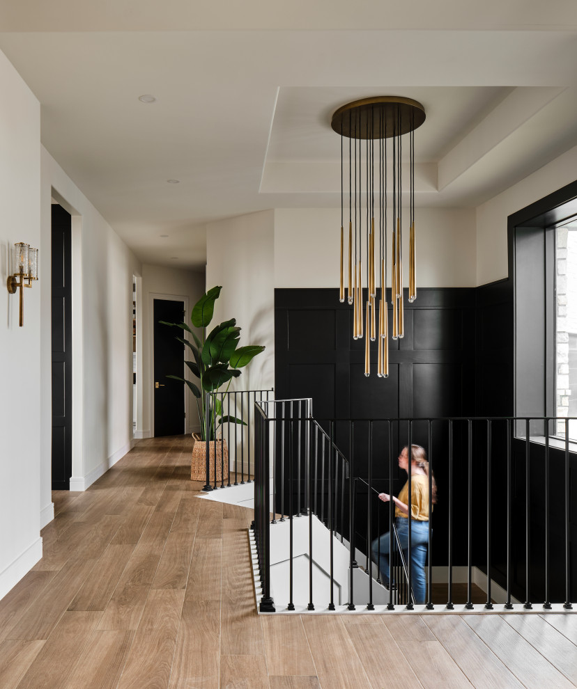 Large transitional tile u-shaped metal railing and wainscoting staircase photo in Omaha with tile risers