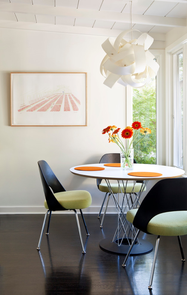 This is an example of a beach style dining room in Santa Barbara with white walls and dark hardwood floors.