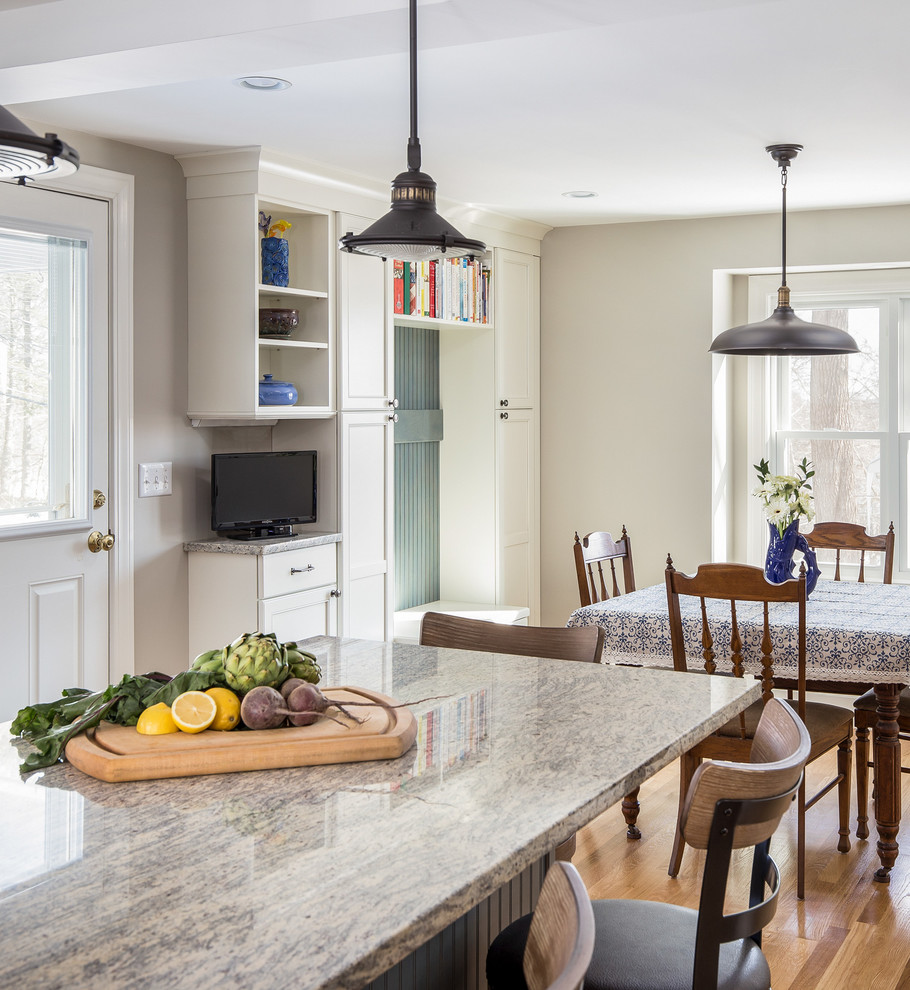 Inspiration for a mid-sized eclectic u-shaped eat-in kitchen in Boston with an undermount sink, flat-panel cabinets, white cabinets, granite benchtops, yellow splashback, subway tile splashback, stainless steel appliances, light hardwood floors and with island.