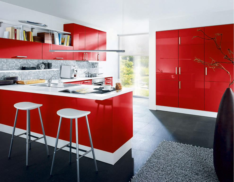 Photo of a mid-sized modern l-shaped eat-in kitchen in Surrey with an undermount sink, flat-panel cabinets, red cabinets, grey splashback, mosaic tile splashback, stainless steel appliances, porcelain floors and a peninsula.