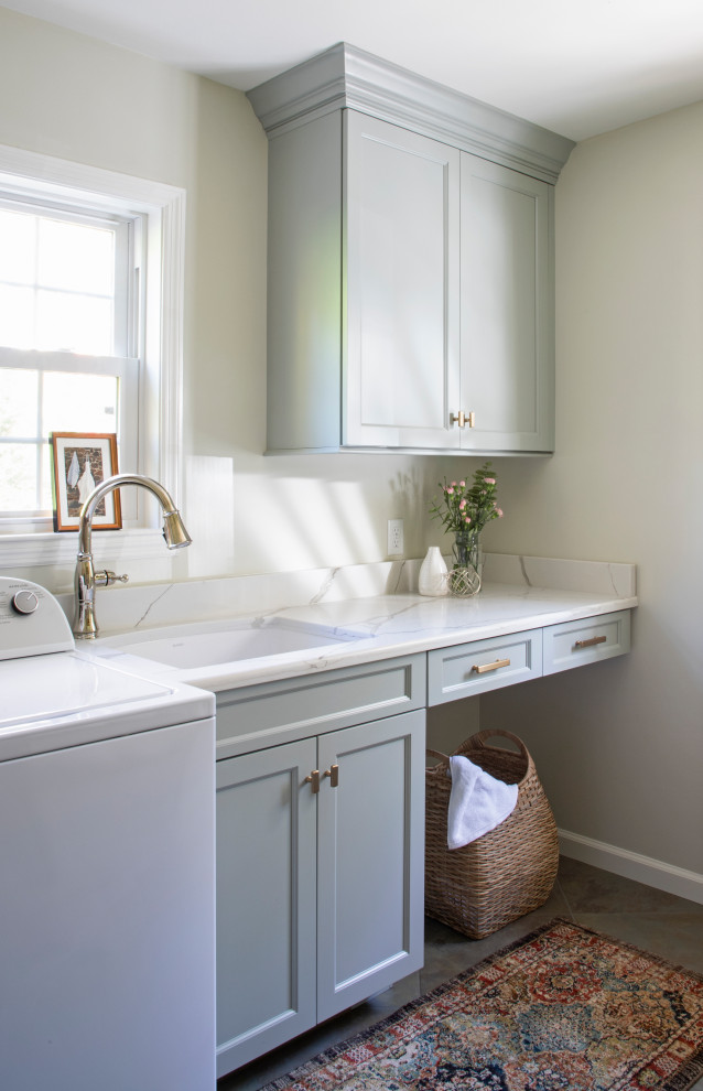 Photo of a traditional utility room in Philadelphia with an undermount sink, shaker cabinets, grey cabinets, quartz benchtops, white splashback, engineered quartz splashback, grey walls, ceramic floors, a side-by-side washer and dryer and white benchtop.