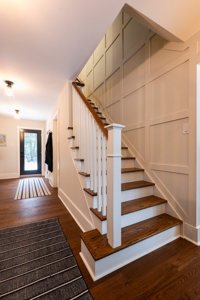 Photo of a mid-sized modern entry hall in Other with white walls, medium hardwood floors, a single front door, a glass front door and brown floor.