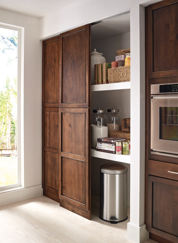 Kitchen pantry - large transitional single-wall light wood floor and beige floor kitchen pantry idea with an island, an undermount sink, recessed-panel cabinets, medium tone wood cabinets and stainless steel appliances