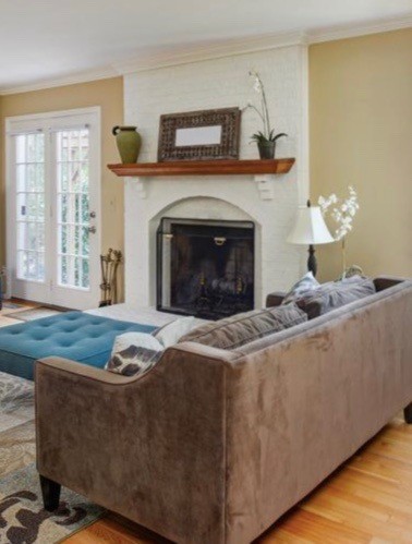 Inspiration for a traditional family room in DC Metro with beige walls, medium hardwood floors, a standard fireplace and a brick fireplace surround.