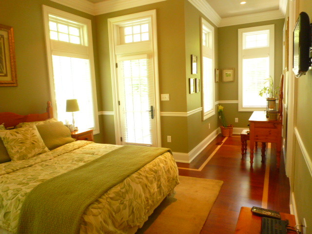 Mid-sized traditional bedroom in New York with green walls and medium hardwood floors.