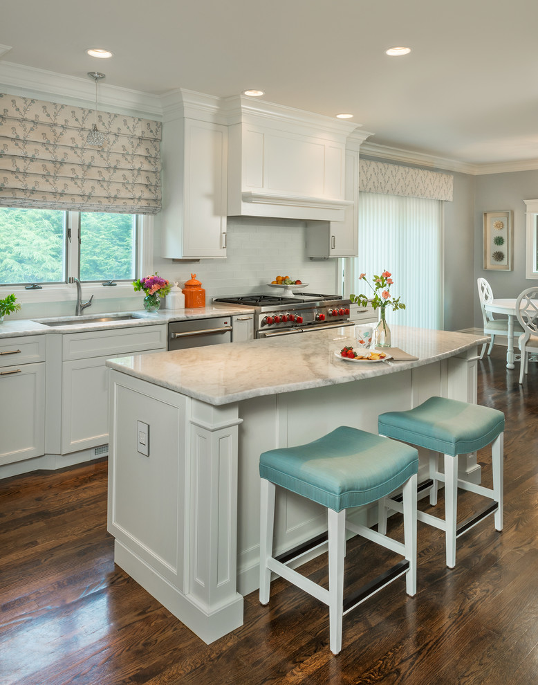 Mid-sized transitional l-shaped dark wood floor eat-in kitchen photo with an undermount sink, recessed-panel cabinets, white cabinets, quartzite countertops, blue backsplash, glass tile backsplash, stainless steel appliances and an island