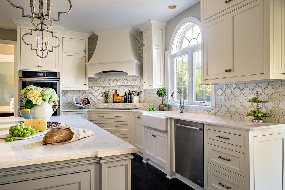This is an example of a transitional open plan kitchen in Nashville with a farmhouse sink, quartz benchtops, white splashback, porcelain splashback, stainless steel appliances, dark hardwood floors and with island.