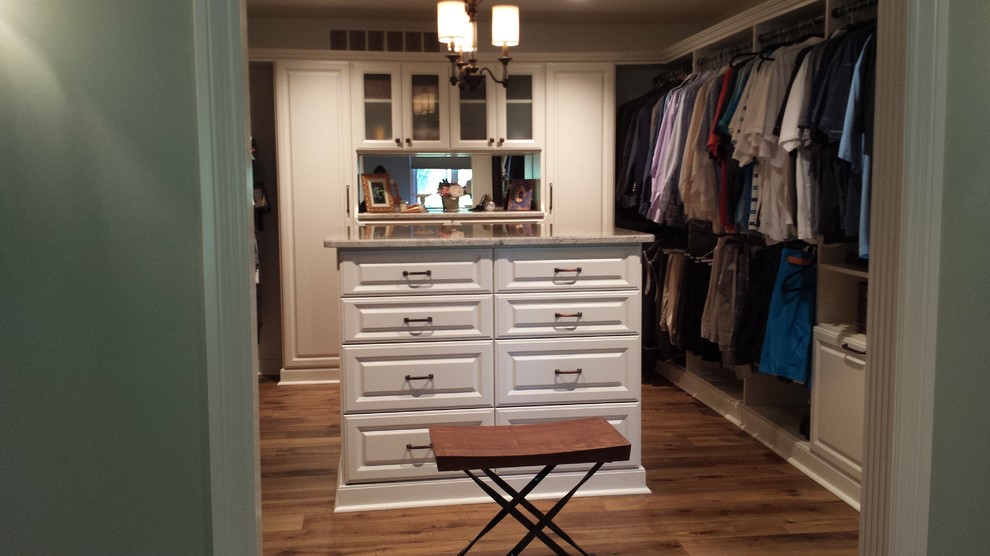 Design ideas for a large transitional gender-neutral walk-in wardrobe with raised-panel cabinets, white cabinets, medium hardwood floors and brown floor.
