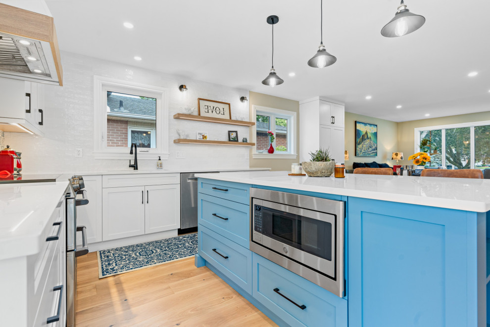 Idéer för att renovera ett mellanstort vit vitt kök, med en undermonterad diskho, skåp i shakerstil, blå skåp, bänkskiva i kvarts, blått stänkskydd, stänkskydd i porslinskakel, rostfria vitvaror, mellanmörkt trägolv och gult golv