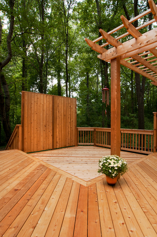 This is an example of a large traditional backyard deck in Atlanta with an outdoor kitchen and a pergola.